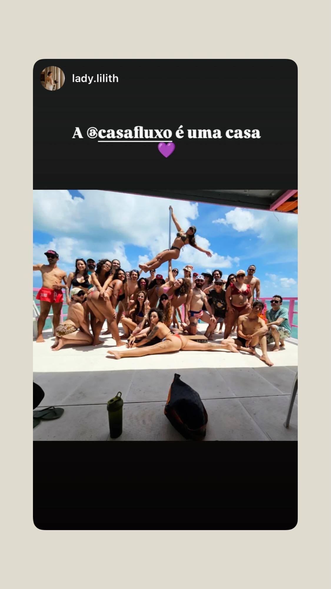 Turma inteira da Casa Fluxo posando no deck do barco com a barra ao centro